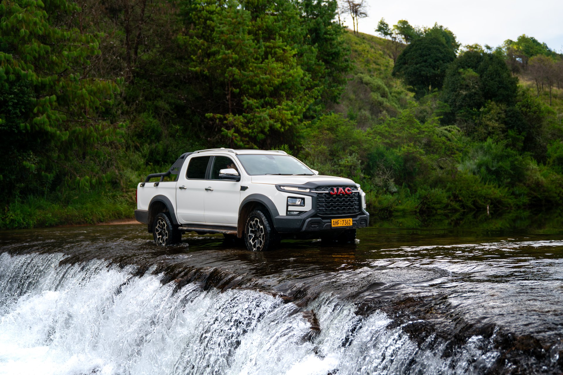 JAC T9 in a river crossing with waterfall
